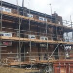 Scaffolding on the side of a building for loft insulation installation.