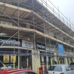 A building with scaffolding in front of it undergoing renovations for loft insulation.