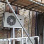 An air conditioning unit is being installed in a building by loft insulation installers.