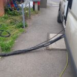 A white van with a hose attached to it used by loft insulation installers.
