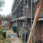 A building under construction with loft ladders being installed.