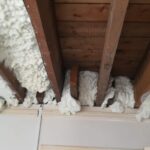 The ceiling of a house is covered with spray foam insulation.