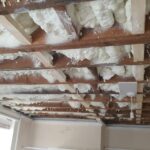 A room with a ceiling covered in white foam created by spray foam insulation.