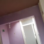 A hallway with purple walls and a purple ceiling.