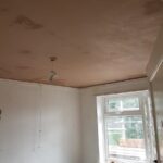 A room with a ceiling that is being repainted, possibly in need of loft insulation.