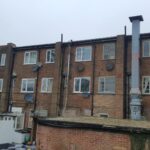 A red brick building with a chimney and loft insulation.