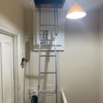 A ladder in a room with a light on it, ideal for loft insulation.