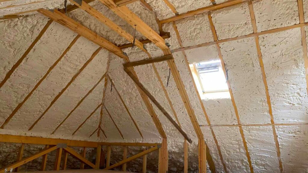 A room with a wooden ceiling and loft insulation.