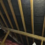 An attic with wooden beams and tarpaulins, perfect for loft insulation.
