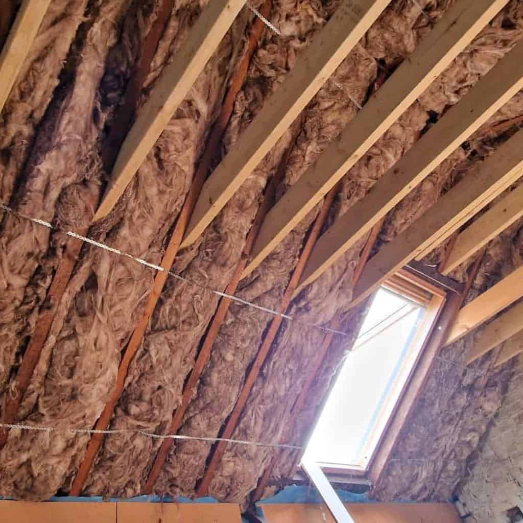 Roof insulation being installed with earthwool insulation and wooden battens.