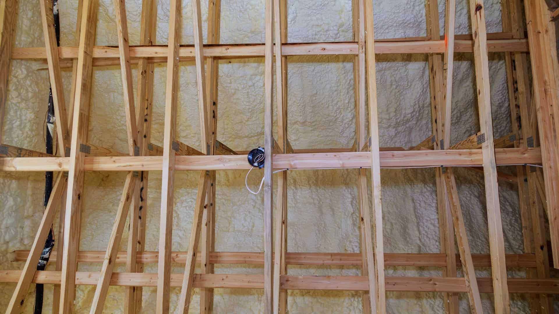 Wooden roof rafters with spray foam insulation installed
