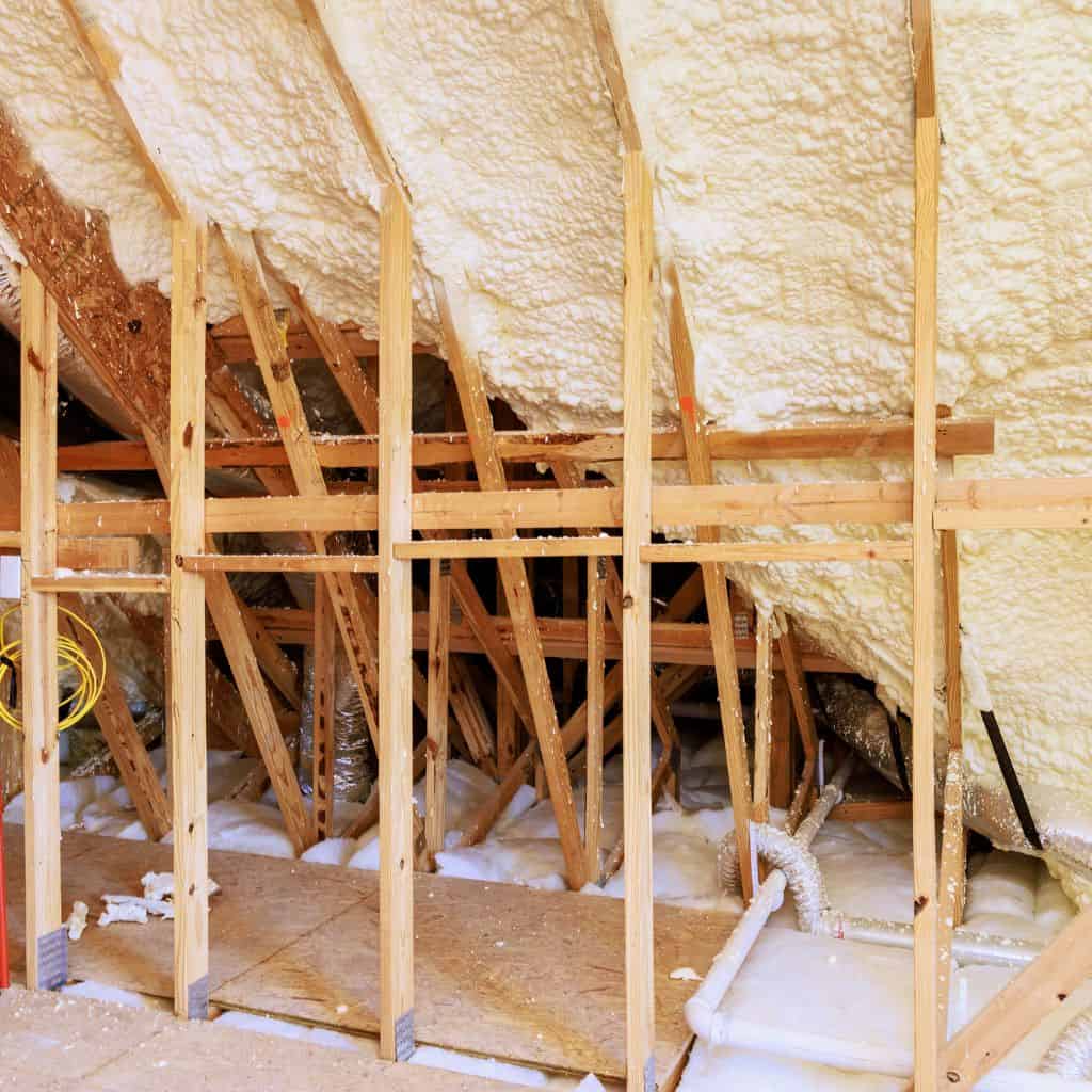 Image of loft spray foam insulation between roof rafters being removed.