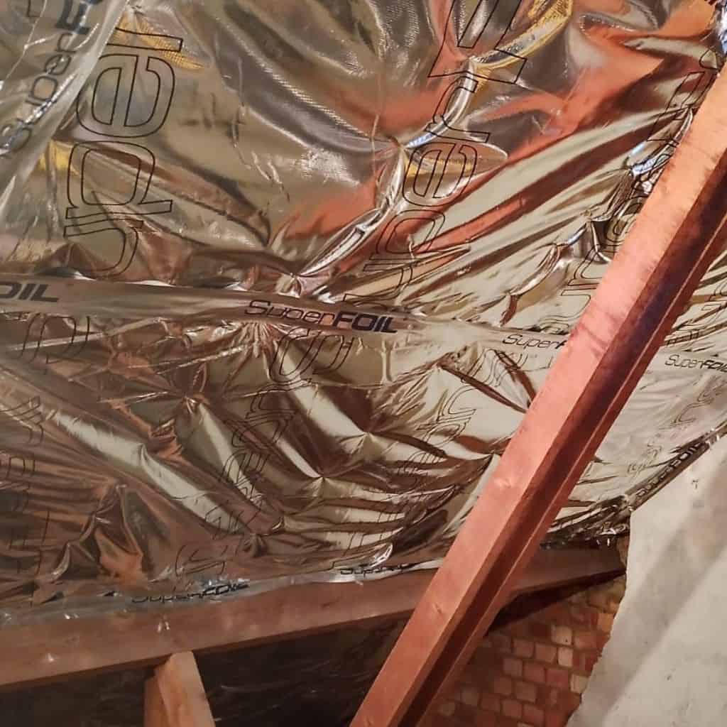 Loft insulation installation using SuperFoil reflective material.