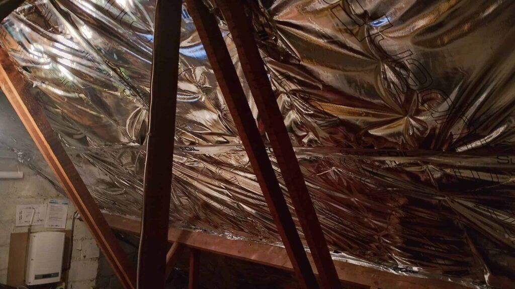 Loft insulation with superfoil insulation material in attic space.