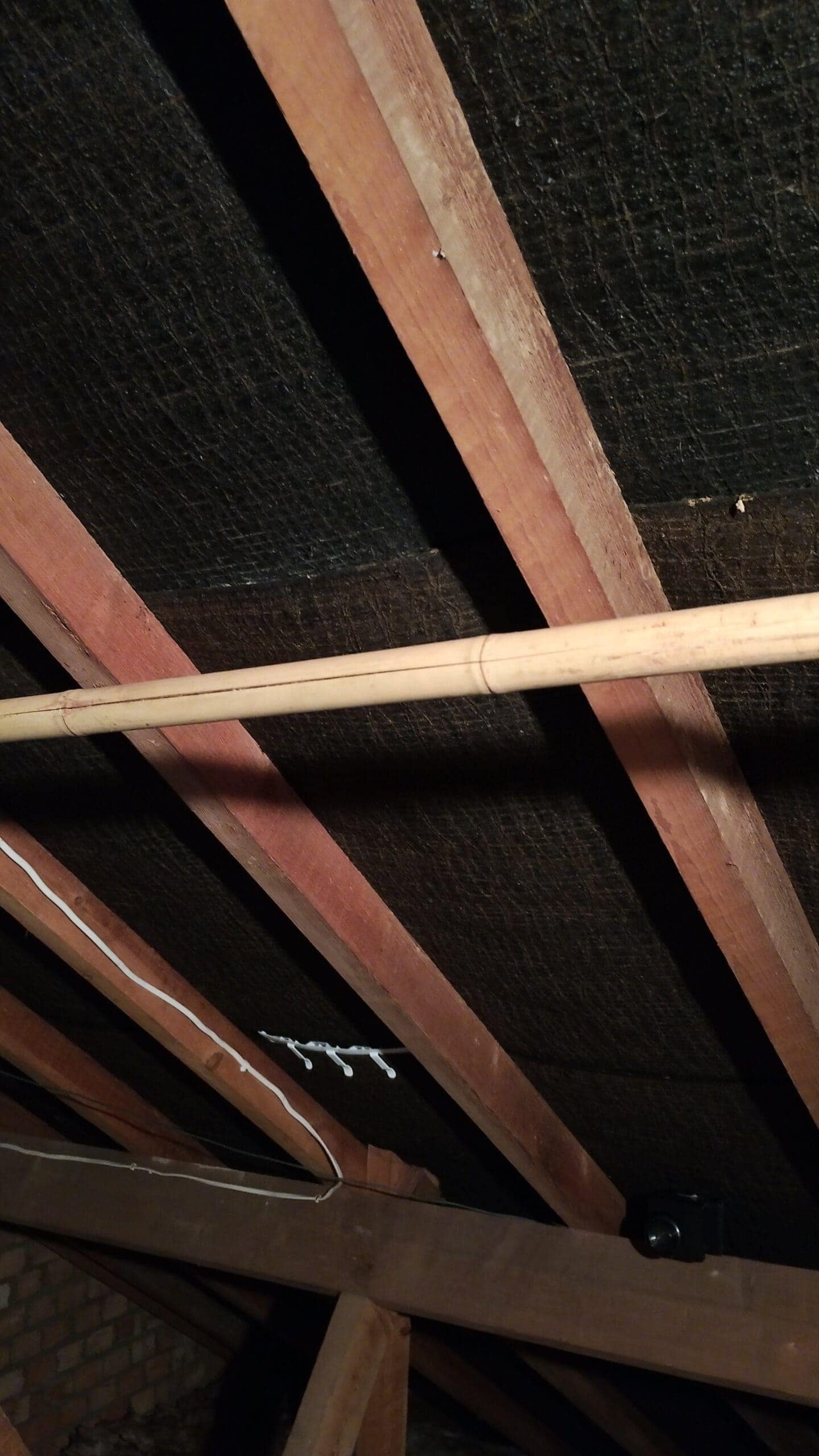 Loft insulation being installed between roof rafters for energy efficiency.