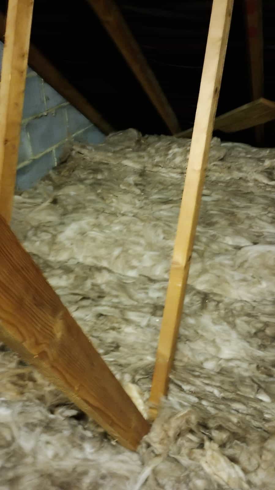 Loft insulation being installed in an attic space for energy efficiency.